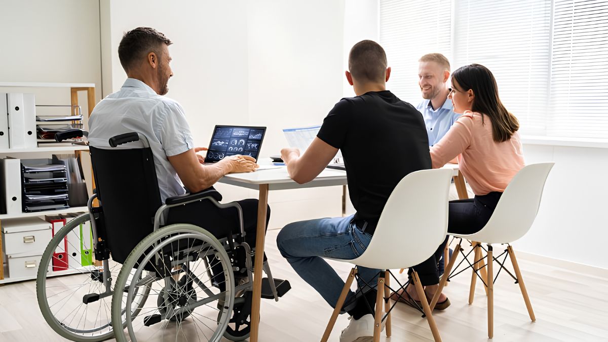 A businessman in a wheelchair participating in an inclusive team meeting at an office table
