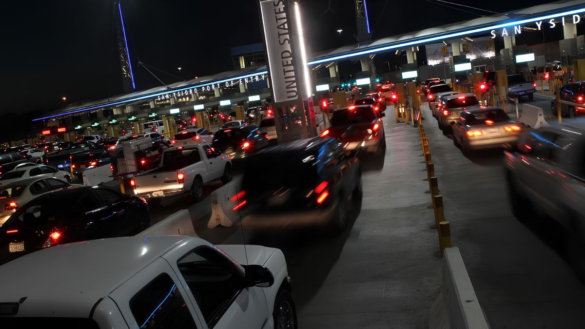 Cars lined up with red brake lights at the San Ysidro Port of Entry border crossing between San Ysidro and Tijuana at night