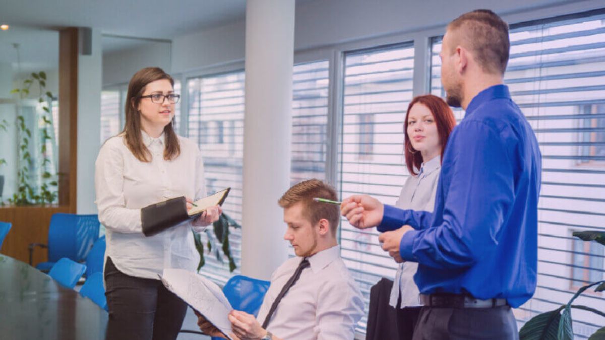 A diverse team of professionals collaborating and reviewing documents during a meeting in a bright office.