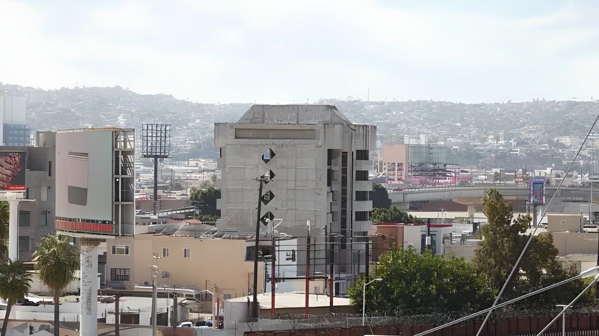 An elevated view of urban architecture, commercial buildings, and billboards in the border region connecting San Ysidro with South Bay communities.