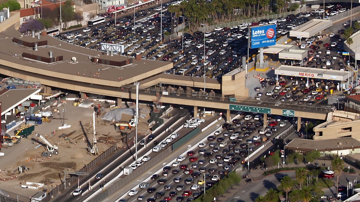 An aerial view of dense vehicle traffic and infrastructure at the San Ysidro border crossing, showing how its location shapes daily life and transportation.