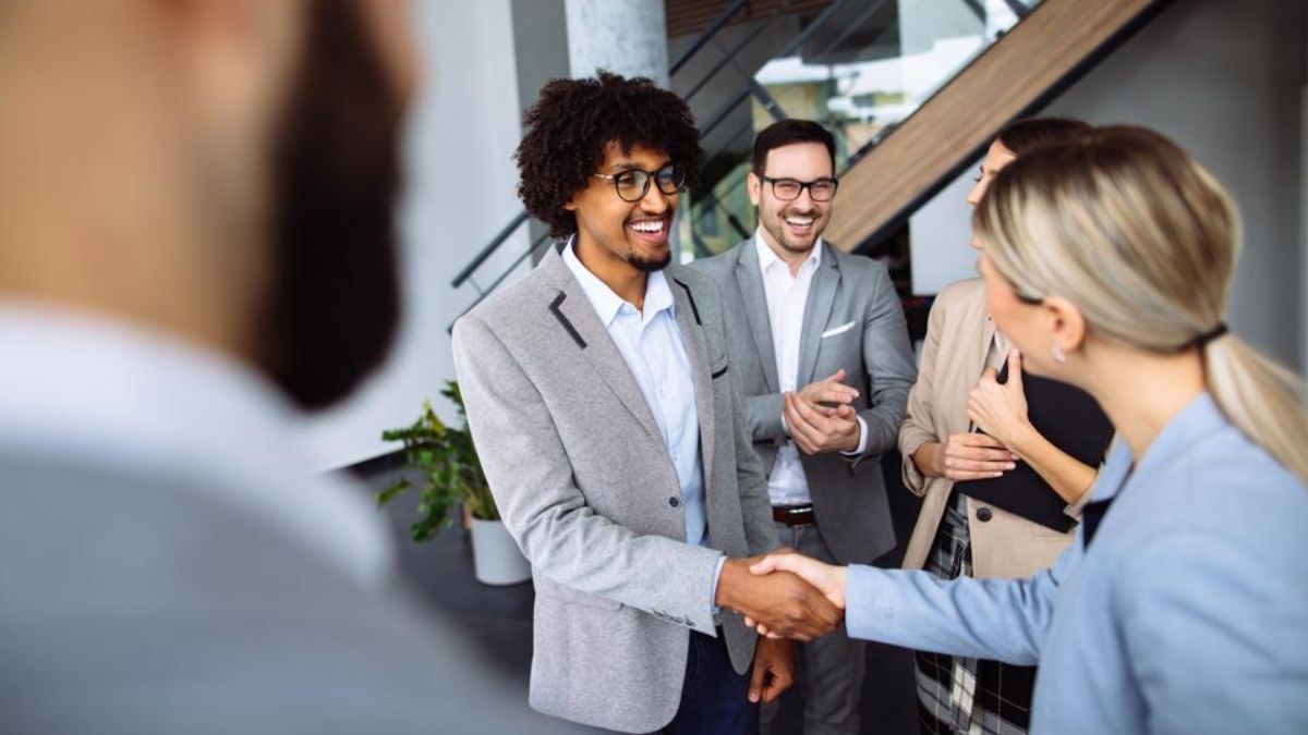 A smiling professional shaking hands with a customer, reflecting strong customer service and lasting loyalty for independent businesses in San Ysidro.