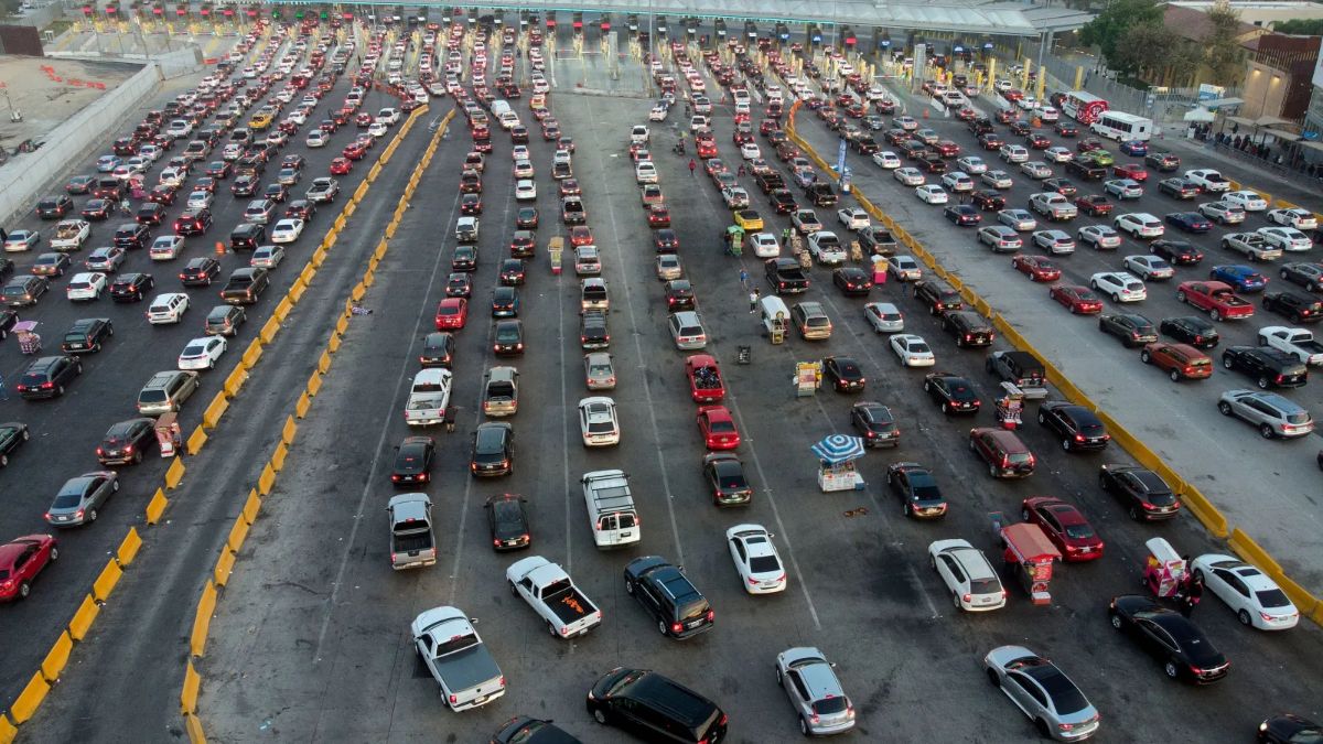 An aerial high-angle view showing massive lines of cars and vehicles waiting at a busy border inspection crossing.