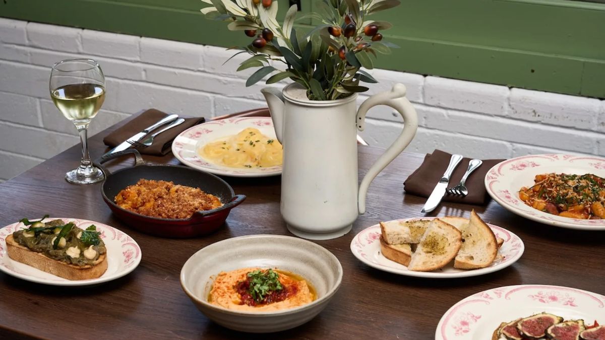 A spread of vegetarian and vegan dishes including hummus, bruschetta, and pasta on a restaurant table