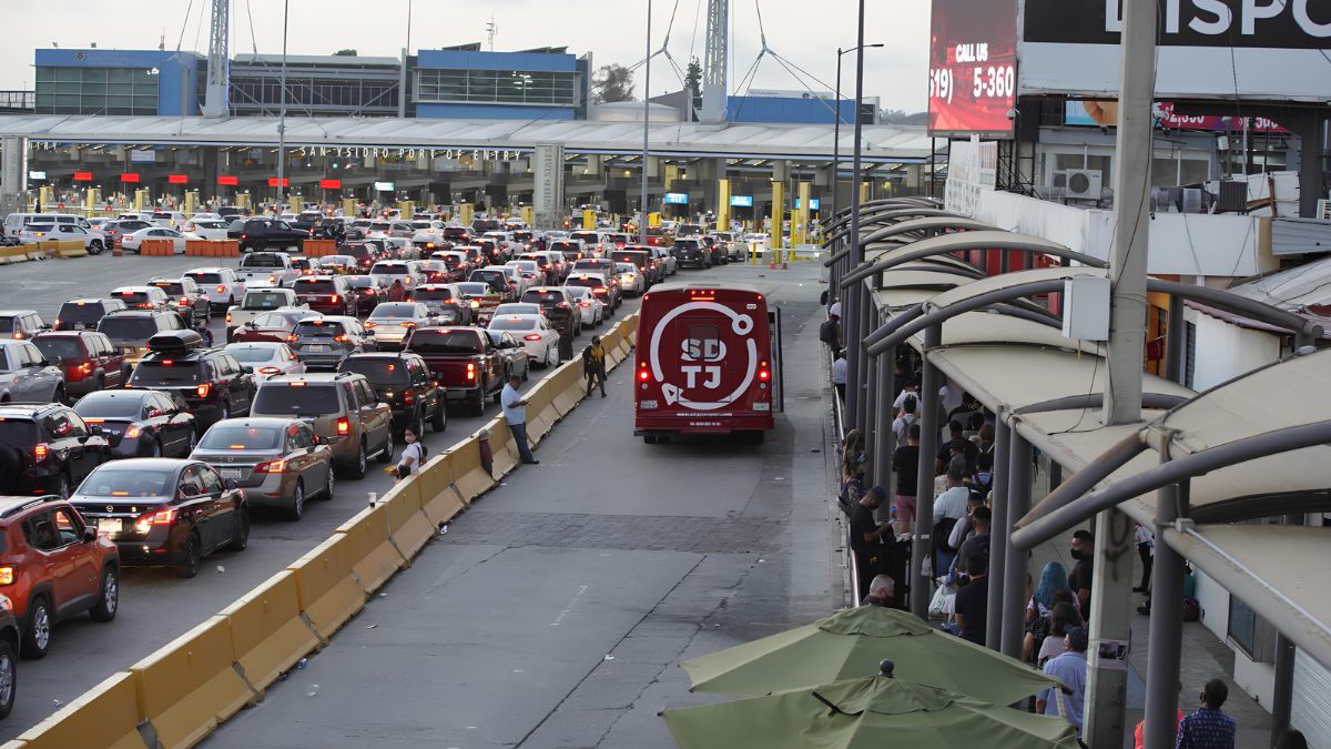 Heavy vehicle traffic and crowds of travelers at the San Ysidro Port of Entry, highlighting cross-border driving and international car rental considerations between San Diego and Tijuana.
