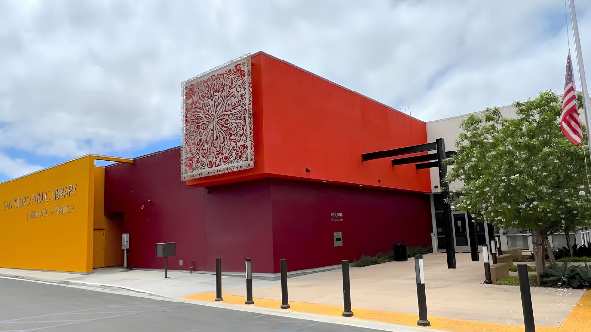 The exterior of the modern San Ysidro Public Library building with bright red and yellow walls, highlighting local neighborhood amenities